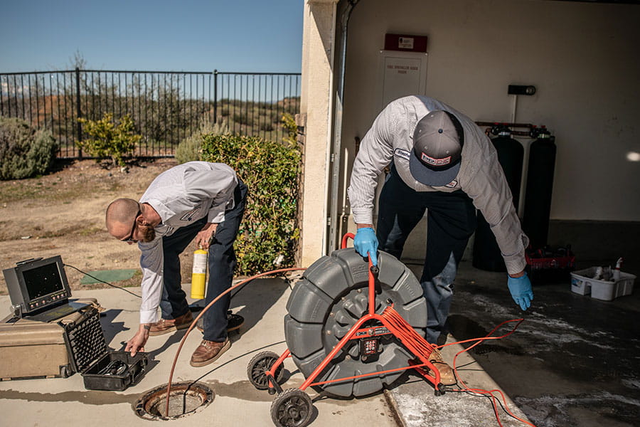Plumbers performing drain cleaning