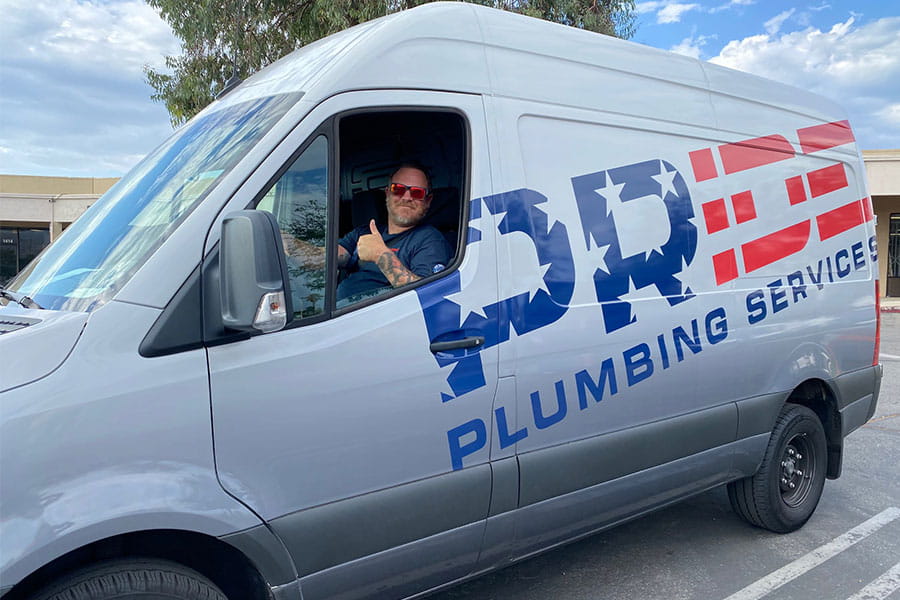 Plumber inside Pride Plumbing service van