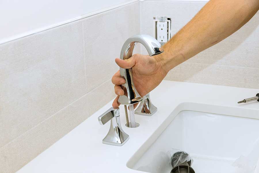 Plumber performing sink and faucet installation